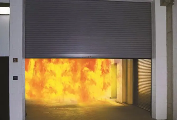 Flames are shooting out of a building equipped with a fire-resistant garage door, providing essential protection.